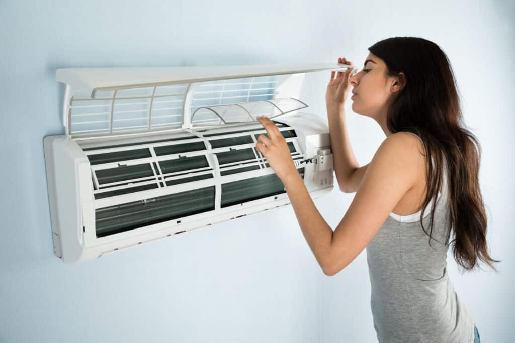 woman looking at broken AC in Shreveport LA